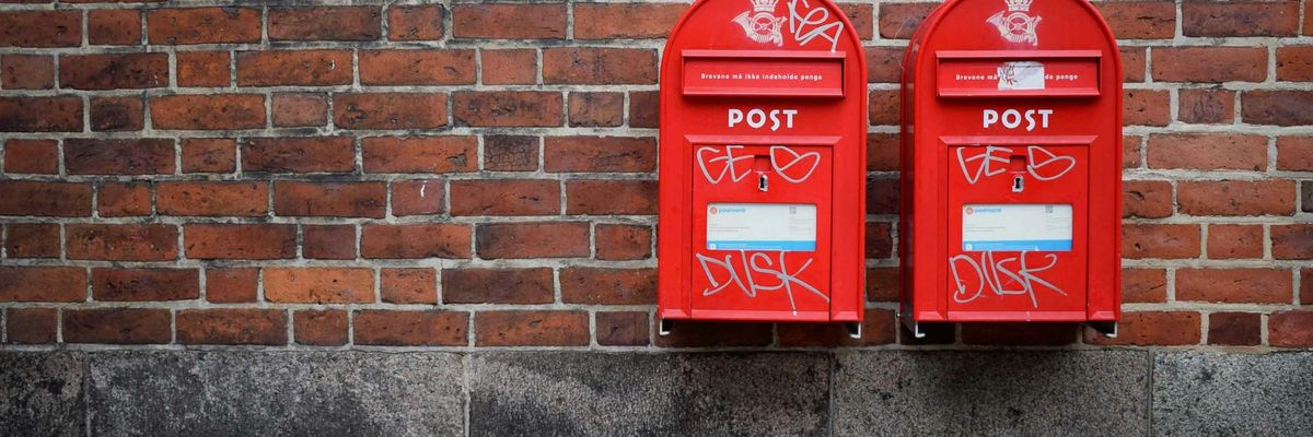 Két piros postaláda egy téglafalon