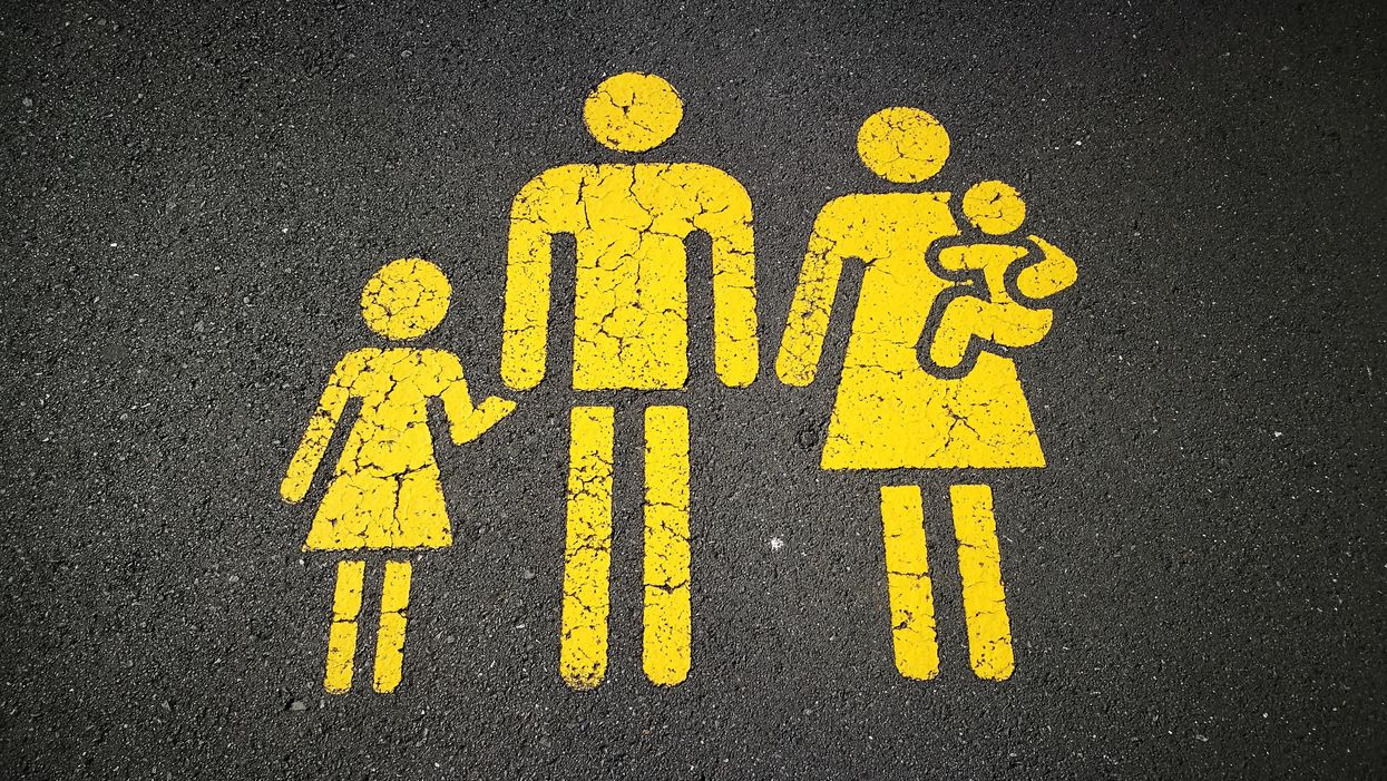 Kétgyerekes családot ábrázoló piktogram az útra festve.