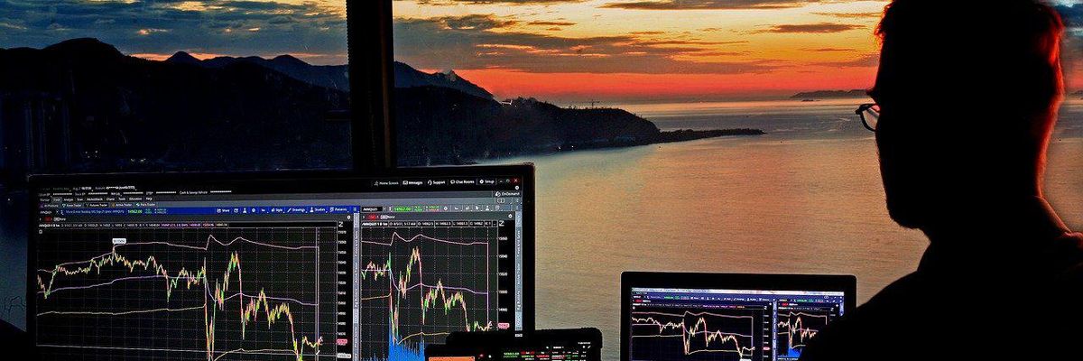 Kockázati tőkés figyeli a részvényárfolyamokat a naplementében a tengerparti háza ablakában