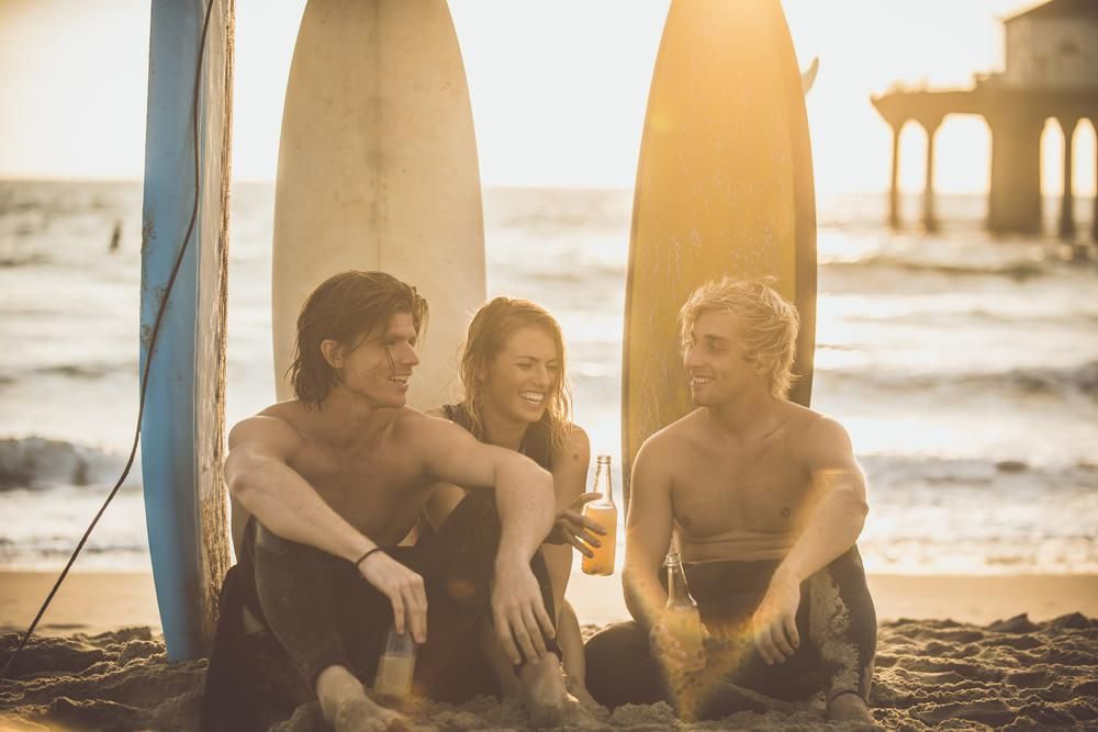 Szörf után fiatalok söröznek az óceánparton Kaliforniában