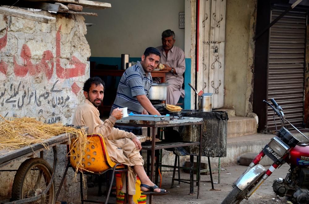 Pakisztáni lepukkadt utcán teát isznak 