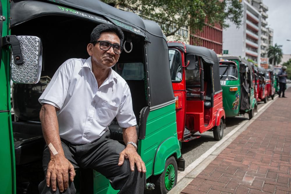 Piros és zöld tuk-tuk autók sorban Srí Lankán benzinre várnak