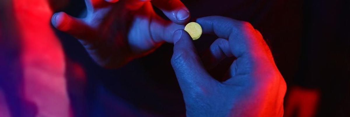 MDMA tablettát ad át egy díler egy vevőnek egy buliban