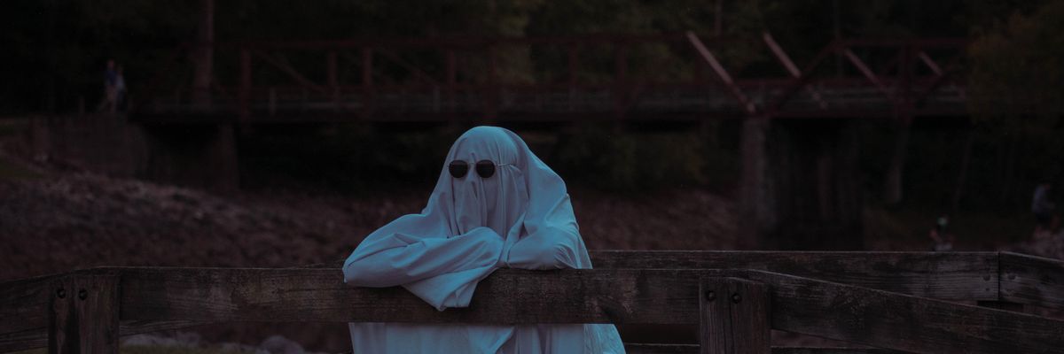 Menő szellem támaszkodik a kerítésen, miközben nézi a horrorfilmek jövedelmezőségét