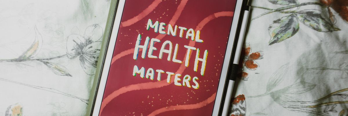 Mental health matters felirat egy iPad-en piros háttérrel egy ágytakarón.