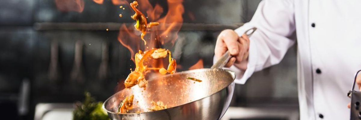 Michelin-csillagos séf fehér séfkabátban ételt készít a Michelin-csillagos étterem konyhájában