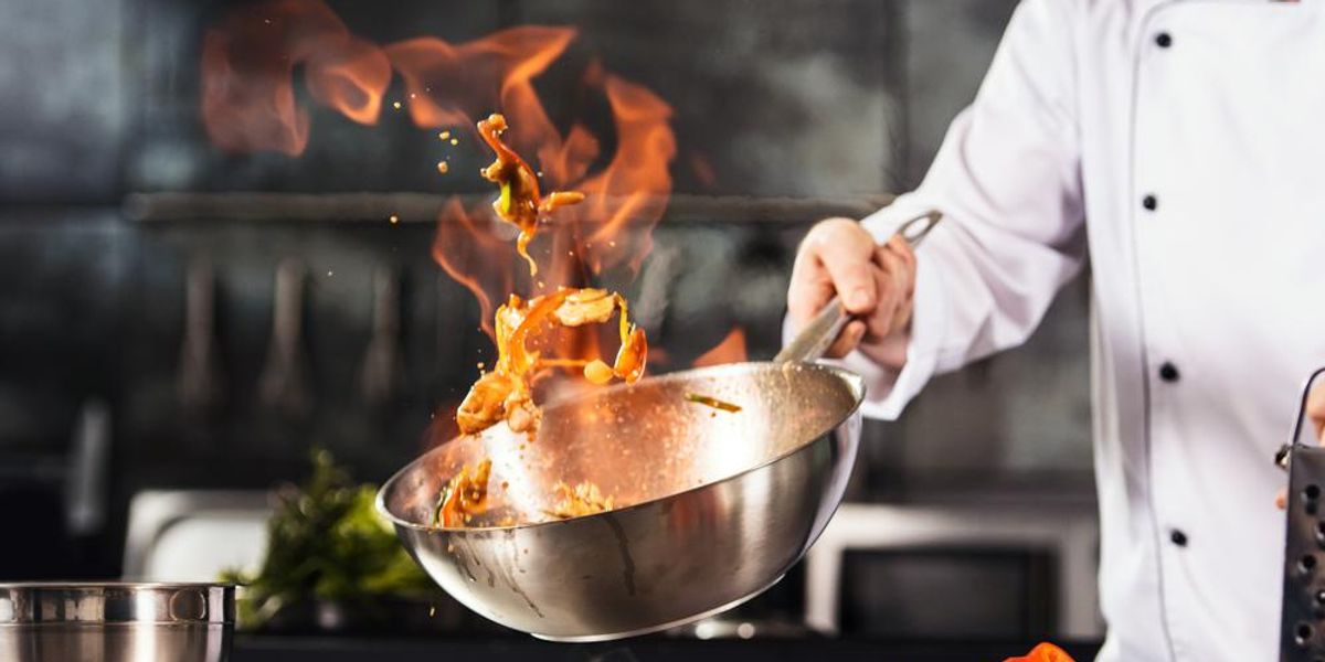 Michelin-csillagos séf fehér séfkabátban ételt készít a Michelin-csillagos étterem konyhájában