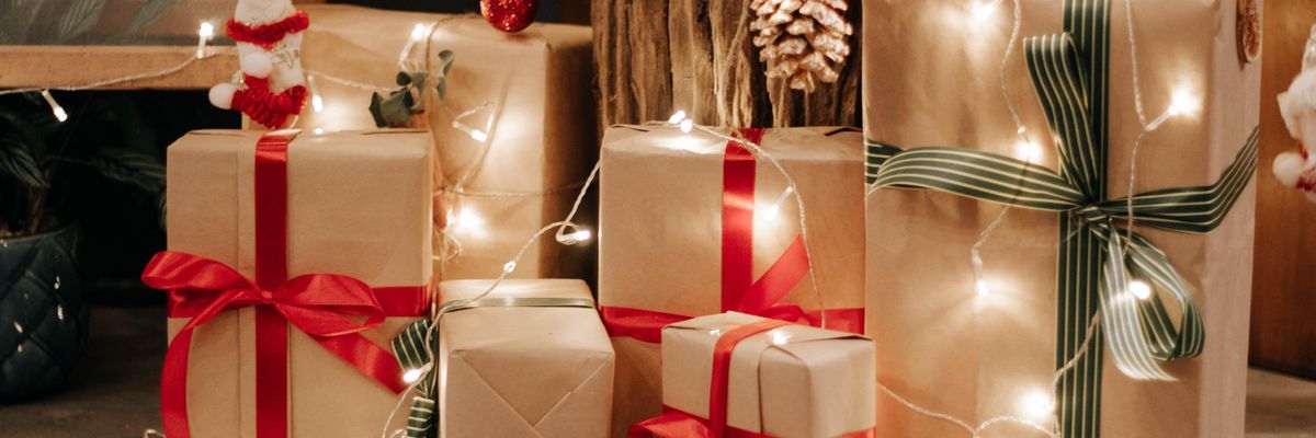 Minimalista stílusú karácsonyi csomagok fényfüzérrel betekerve