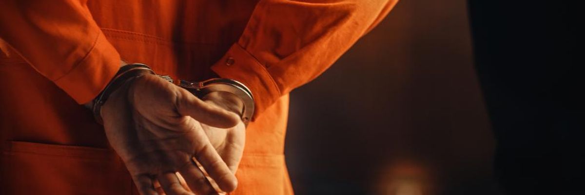 Narancssárga rab ruhában, bilincsben kíséri a börtönőr a cellájába az informatikust, aki meghackelte munkaadói rendszereit