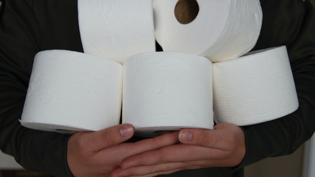 Öt WC-papír gurigát tart kezében egy ember