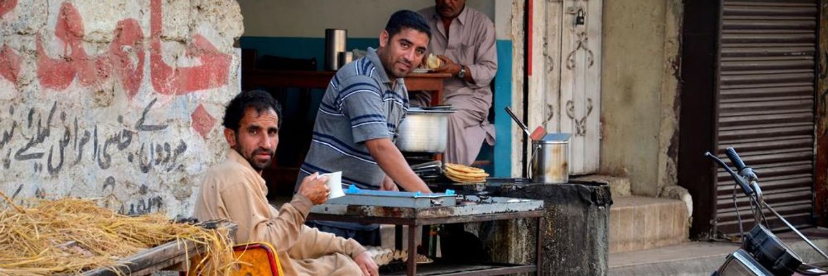 Pakisztáni lepukkadt utcán teát isznak 