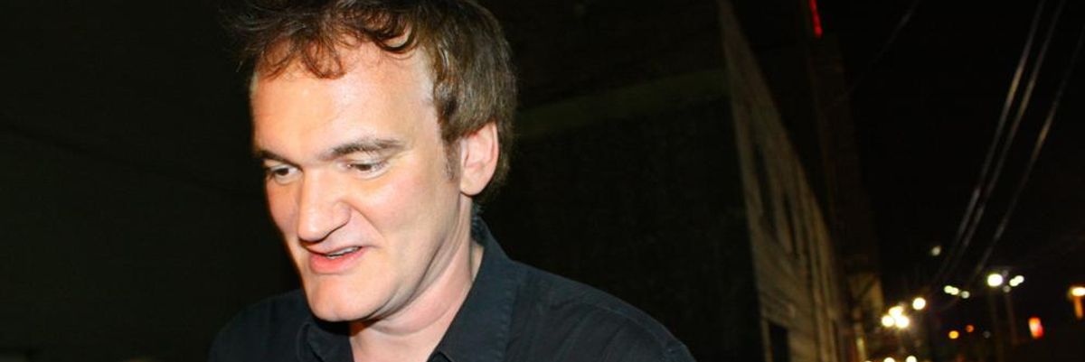 Quentin Tarantino fekete ingben mosolyogva sétál a rajongói előtt