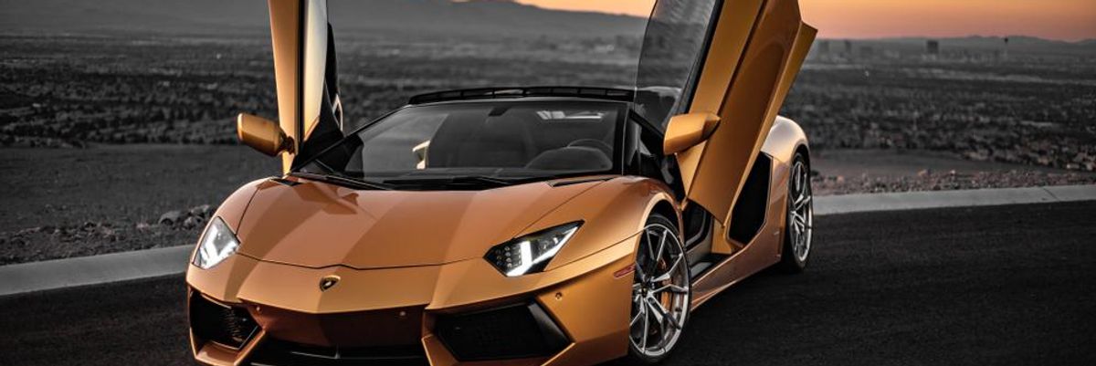Sárga Lamborghini nyitott ajtókkal egy úton, naplementében, egyhamar nem lesz a szuperautóból teljesen elektromos változat