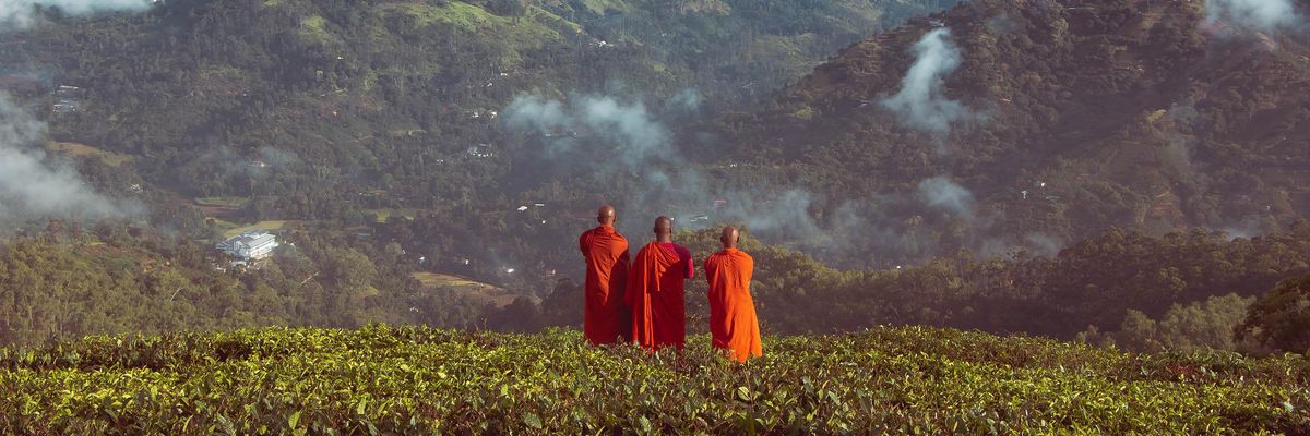 Sárga ruhába öltözött három szerzetes a hegy előtt
