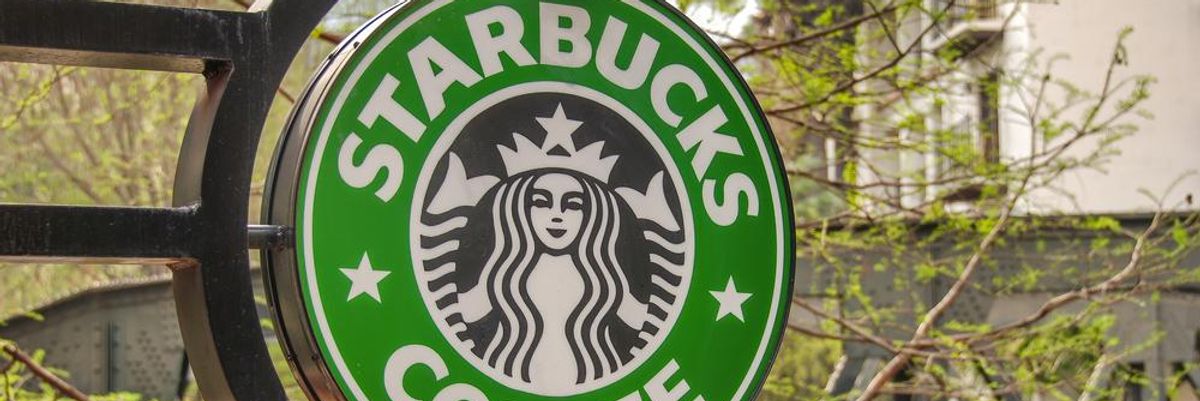 Starbucks logó zöld faleveles ágakkal a háttérben 