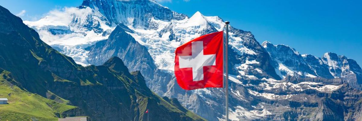 Svájc hőfödte hegycsúcsok, piros-fehér zászlóval