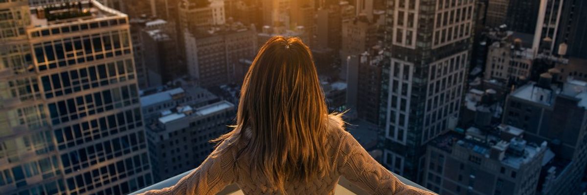 Tehetős nő élvezi a naplementét New Yorkban egy teraszon