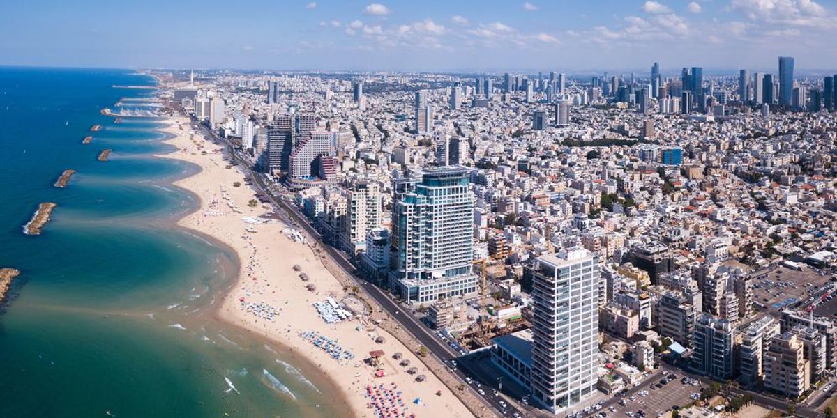 Tel Aviv szállodákkal és házakkal zsúfolt tengerpartja napsütéses időben, Tel Avivban a legdrágább az élet 