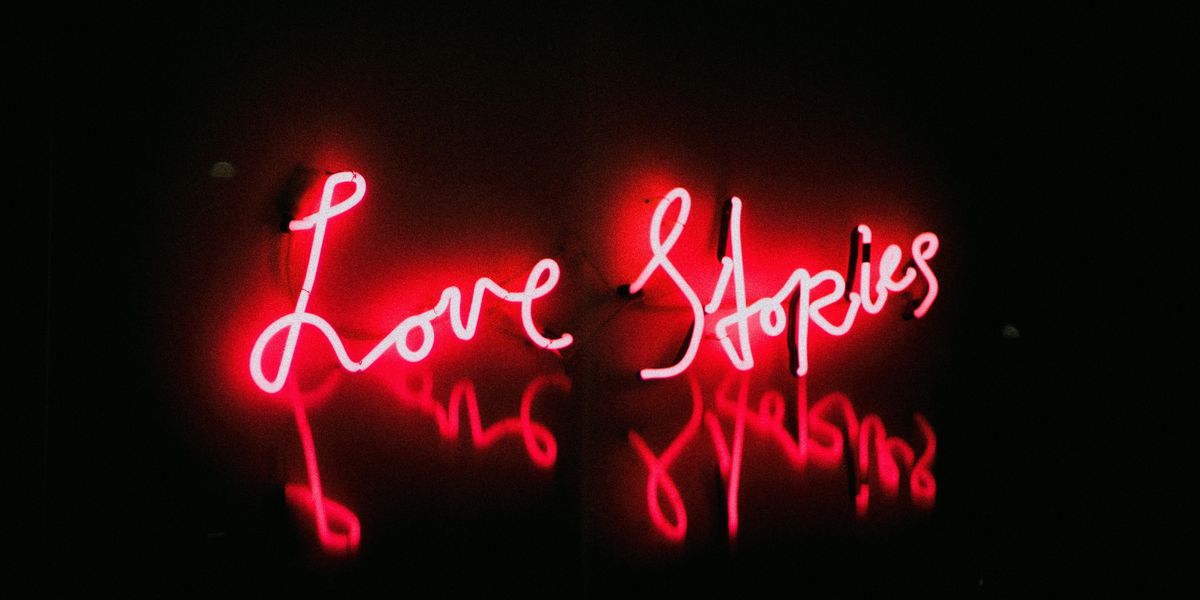 Tinderes érzetet keltő Love stories piros felirat fekete háttér előtt