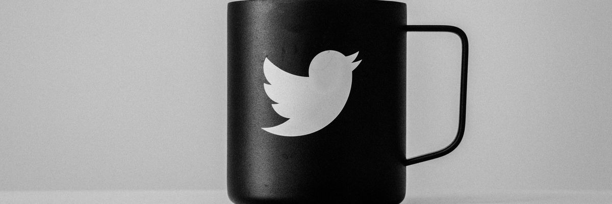 Twitter emblémája egy fekete bögrén fehér környezetben