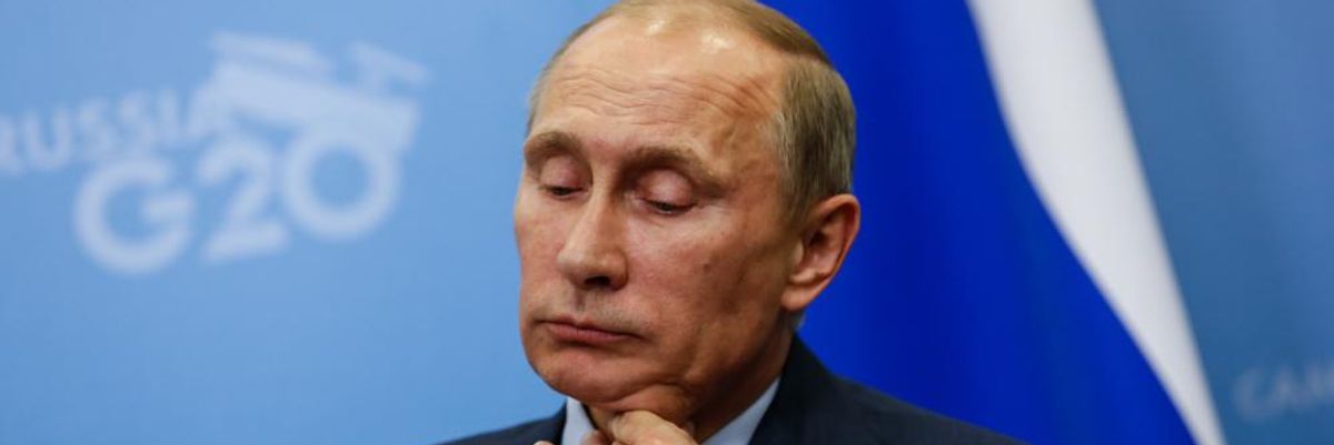 Valgyimir Putyin orosz elnök a gigáját fogja az orosz zászló előtt, miután rájött, hogy egy tini nyomon követi a repülőjét