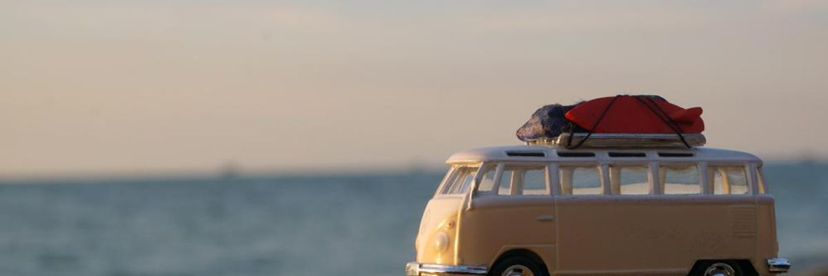 Világosságárga Volkswagen kisbusz a tengerparti sziklán