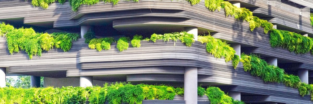 Zöld társasház növényekkel teleültetett erkélyekkel