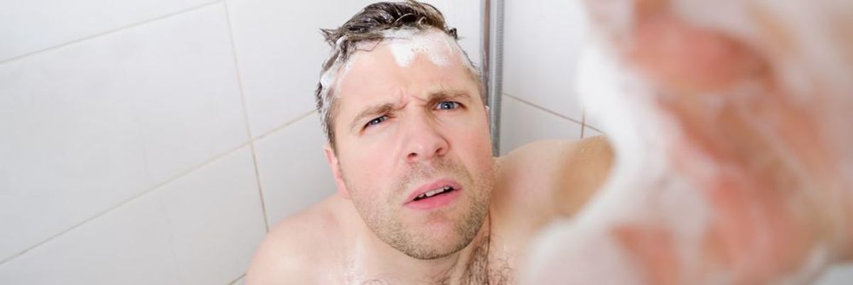 Zuhanyzó férfi rejtett kamerába néz